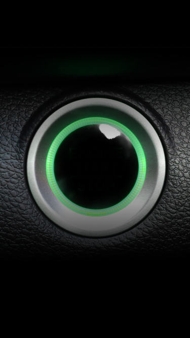 A car engine start button in green.